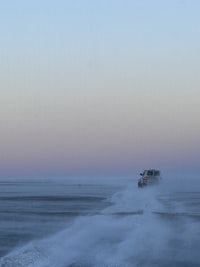 a truck driving on a snowy road at dusk