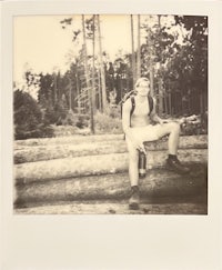 a man sitting on a log in the woods