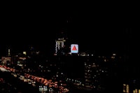 a city at night with a red light on top of a building