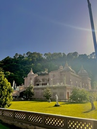 a temple with a lot of grass and trees in the background