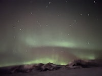 the aurora borealis is seen through a window in a dark room