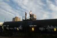 two men standing on top of a train