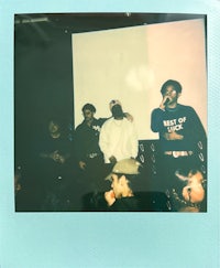 a group of people standing in front of a blue polaroid