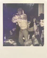 a polaroid photo of a man holding a microphone