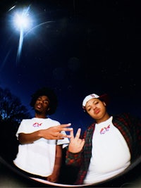 two young men posing for a picture in front of a starry sky