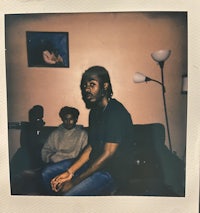 a polaroid photo of a man sitting on a couch