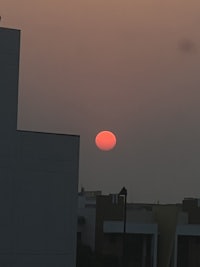 a sun rising over a city with buildings in the background