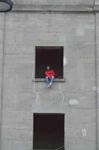 a person sitting in a window of a building